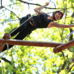 atractive woman climbing in adventure rope park