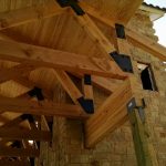 Up close view of timber trusses for building exterior in Lender, Tx.
