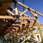 Side under view of timber trusses for building exterior in Lender, Tx.